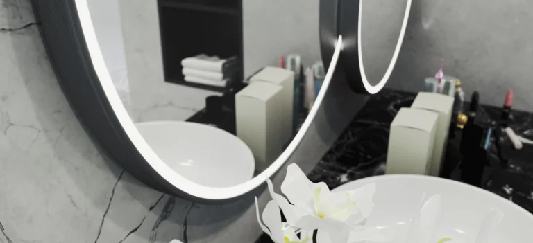Lighted aluminum framed mirror with white orchid and sink below in Saudi Arabia.
