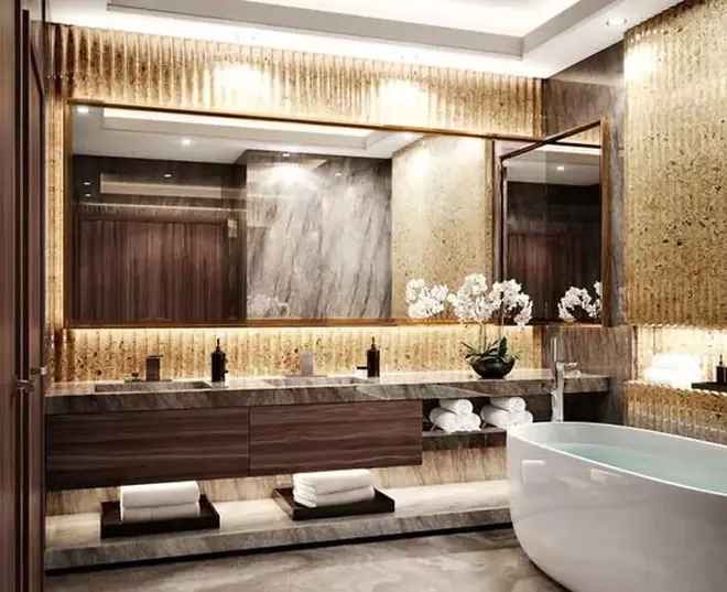 Above the bathroom faucet is a wall mounted lit mirror with a wooden frame from Saudi Arabia.