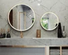 Preview of circular mirrors bound on a marble wall above a gray stone countertop in Sharjah.