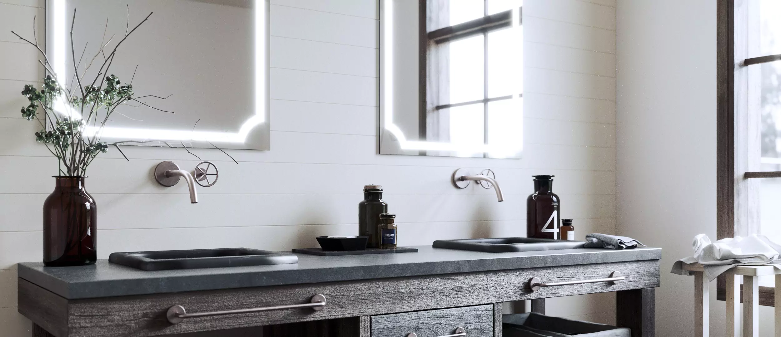 Grand Mirrors Lux on a white concrete wall and a black iron countertop with two sinks in Sharjah.