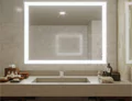 Tiny of vanity mirror mounted on a marble wall above a bathroom essentials on a sink in Sharjah.