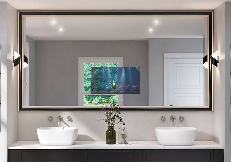 Mirror TV above the double white sink with dried flowers on a bottle placed on a countertop.