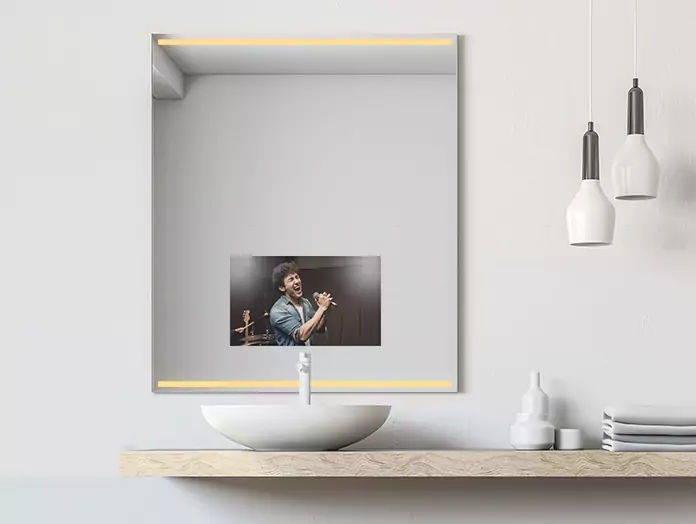 Warm-light strips are built into a mirror TV mounted above a lone sink.