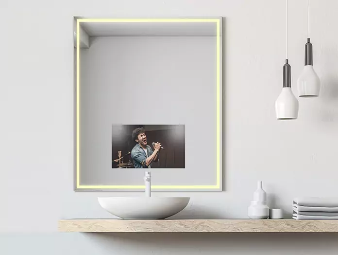 Mid-warm, lighted mirror TV with a man singing on its screen above a white washbowl.