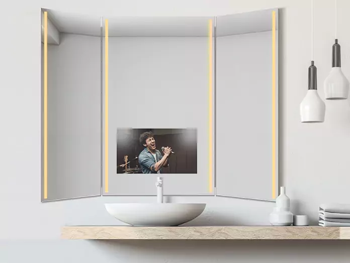 White pendant lamp beside a sole trifold mirror TV with warm light strips placed above a basin.