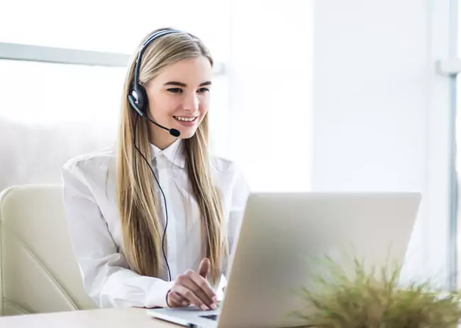 Asistente virtual en Chitré trabajando con su ordenador portátil y auriculares.