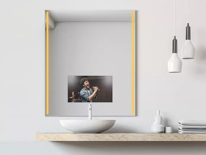 Televisor espejo con iluminación cálida Philips integrada en ambos lados, que muestra a un hombre cantando en Santiago.