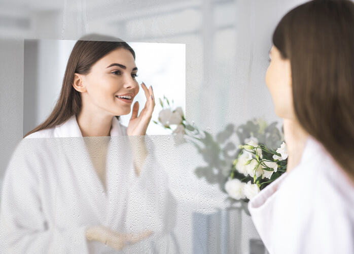 MirrorVue Mirror TV Defogger Technology used by a woman getting ready in the bathroom