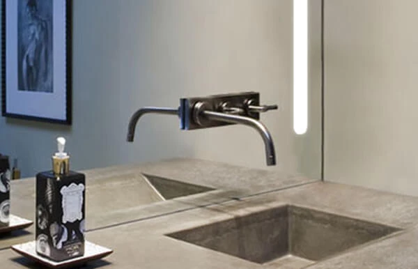 A faucet in the mirror that has light bar on the left corner and a liquid soap on the right side.