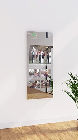 A white wall displays the fitness mirror in a wall mount design, showing videos for exercising.