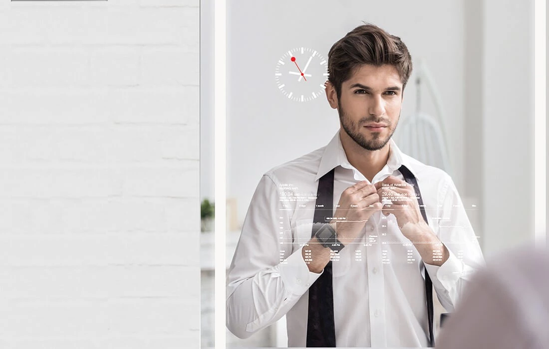A man fixing his tie while looking at his reflection on a digital mirror TV.