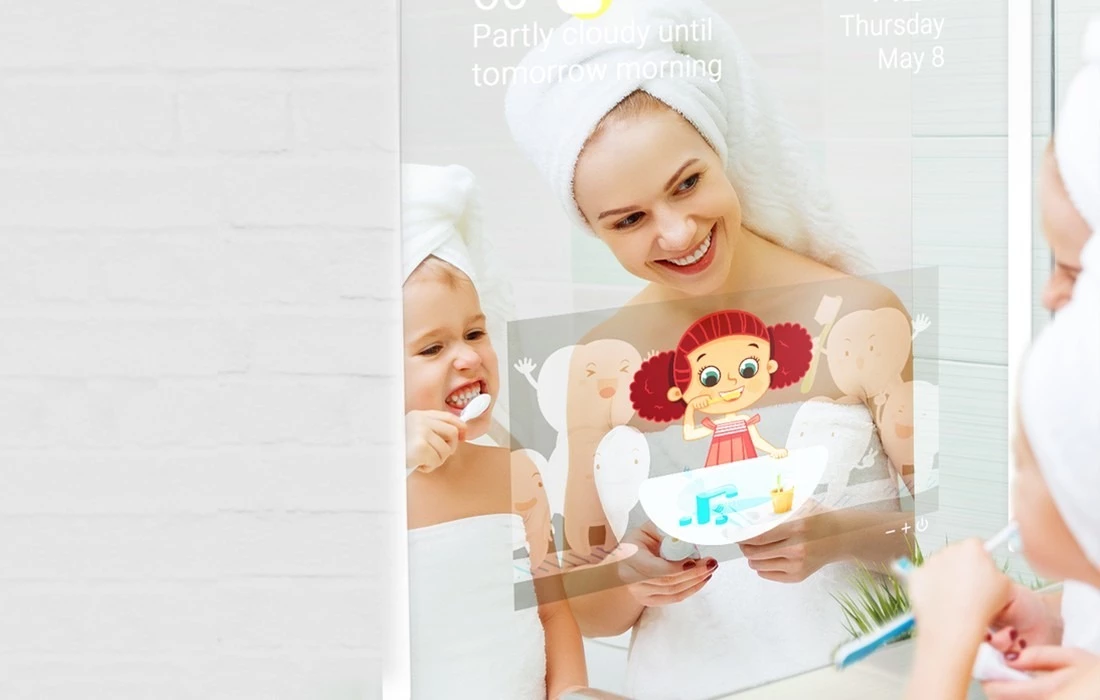 A woman and a child brushing teeth together in front of a smart mirror TV.