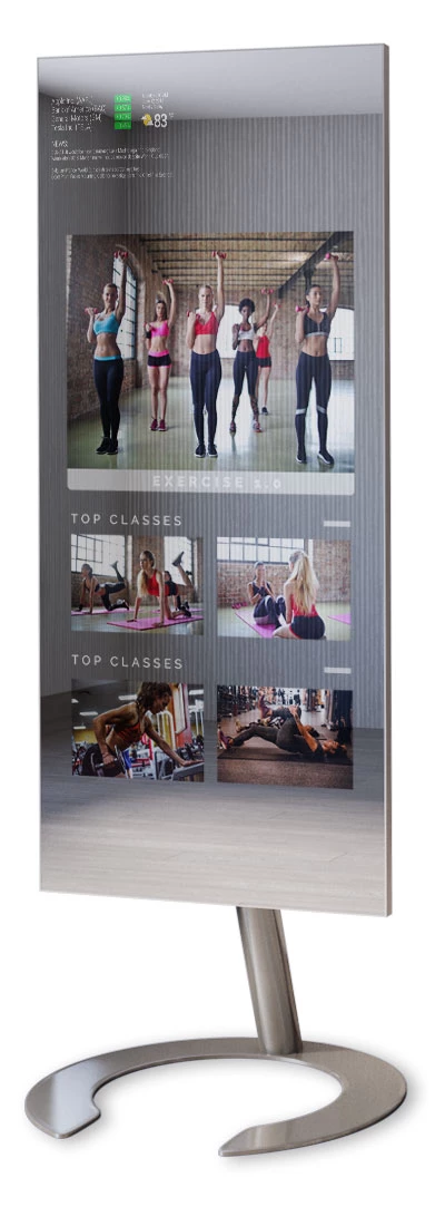 A stable-mounted fitness mirror with women working out on its screen and a mirrorfeeds at the top.